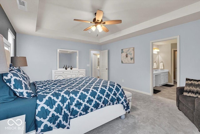 13495 Forest Glade Dr, Fishers, IN 46037 - bedroom with carpet flooring, a raised ceiling, baseboards, connected bathroom, and a ceiling fan