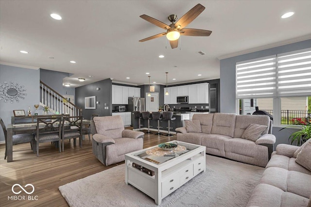 13495 Forest Glade Dr, Fishers, IN 46037 - living area featuring ornamental molding, stairway, wood finished floors, ceiling fan, and recessed lighting