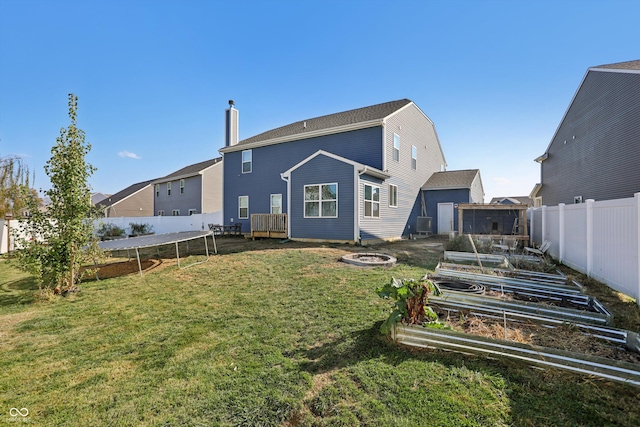 1664 Woodside Cir, Franklin, IN 46131 - back of house featuring a vegetable garden, a fenced backyard, a chimney, and a trampoline
