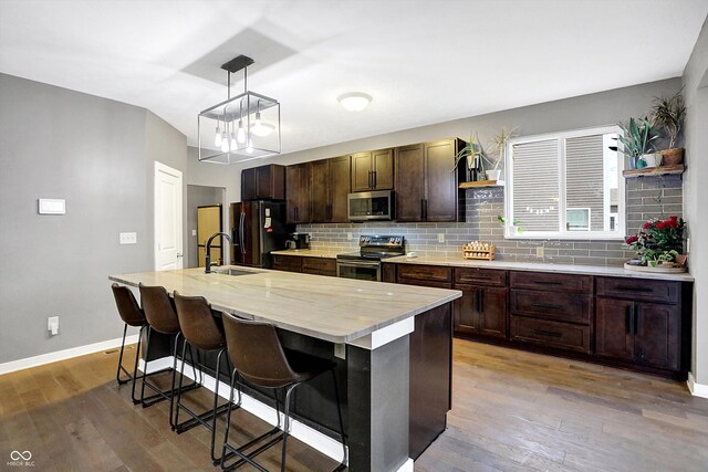 1664 Woodside Cir, Franklin, IN 46131 - kitchen featuring stainless steel appliances, open shelves, wood finished floors, decorative backsplash, and dark brown cabinets