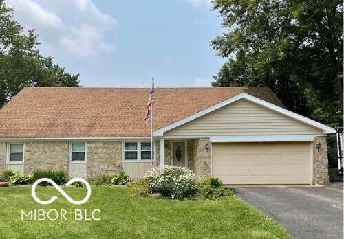 18906 Crestview Ct, Westfield, IN 46074 - ranch-style house featuring stone siding, a garage, a front yard, and driveway