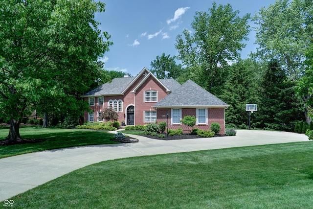 9154 Sargent Manor Ct, Indianapolis, IN 46256 - view of front facade with a front yard, brick siding, a chimney, a shingled roof, and concrete driveway