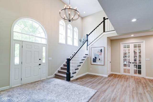 9154 Sargent Manor Ct, Indianapolis, IN 46256 - foyer entrance featuring a towering ceiling, a chandelier, stairway, wood finished floors, and healthy amount of natural light