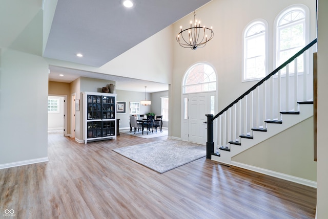 9154 Sargent Manor Ct, Indianapolis, IN 46256 - foyer entrance with a chandelier, wood finished floors, stairs, a towering ceiling, and baseboards