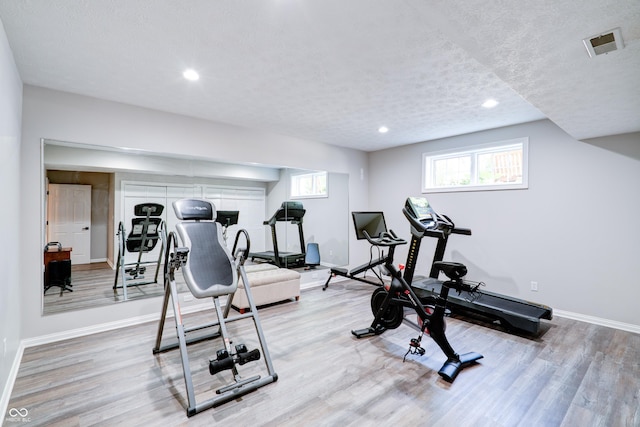 9154 Sargent Manor Ct, Indianapolis, IN 46256 - exercise room featuring baseboards, light wood finished floors, a textured ceiling, and recessed lighting