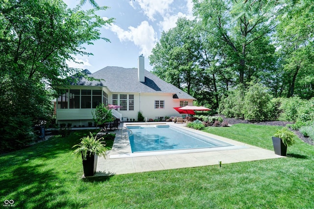 9154 Sargent Manor Ct, Indianapolis, IN 46256 - rear view of house featuring a sunroom, a patio area, a chimney, and a lawn