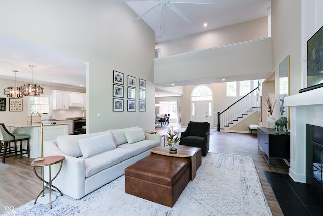 9154 Sargent Manor Ct, Indianapolis, IN 46256 - living room with a towering ceiling, ceiling fan, stairs, wood finished floors, and a fireplace with flush hearth