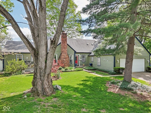 6210 Mckinley Ct, Indianapolis, IN 46220 - cape cod home with concrete driveway, a front yard, and a chimney