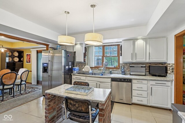 6210 Mckinley Ct, Indianapolis, IN 46220 - kitchen with appliances with stainless steel finishes, light tile patterned flooring, backsplash, a sink, and pendant lighting