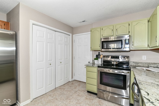 15411 Wandering Way, Noblesville, IN 46060 - kitchen with stainless steel appliances, green cabinetry, a textured ceiling, and light stone countertops
