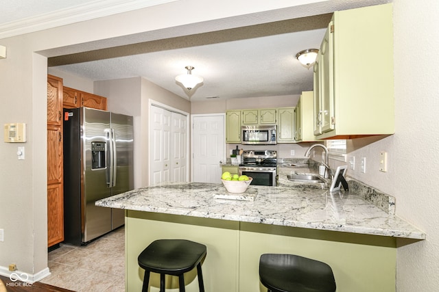 15411 Wandering Way, Noblesville, IN 46060 - kitchen with stainless steel appliances, a peninsula, a sink, green cabinetry, and baseboards