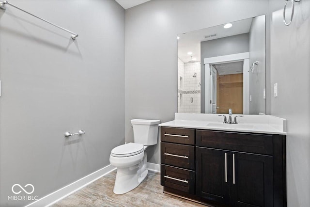 2448 Broadway St, Indianapolis, IN 46205 - full bathroom with toilet, vanity, baseboards, wood finished floors, and tiled shower
