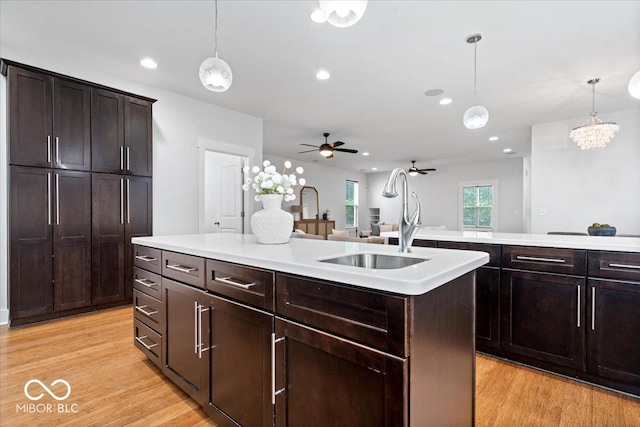 2448 Broadway St, Indianapolis, IN 46205 - kitchen with a sink, ceiling fan, a center island with sink, hanging light fixtures, and light countertops