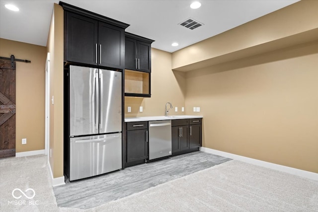 2448 Broadway St, Indianapolis, IN 46205 - kitchen with stainless steel appliances, a barn door, a sink, baseboards, and recessed lighting
