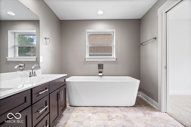 2448 Broadway St, Indianapolis, IN 46205 - bathroom featuring a soaking tub, double vanity, and baseboards