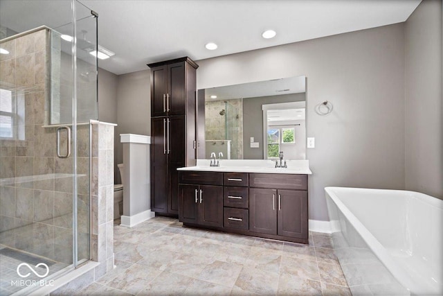 2448 Broadway St, Indianapolis, IN 46205 - bathroom featuring a shower stall, double vanity, a freestanding bath, baseboards, and toilet