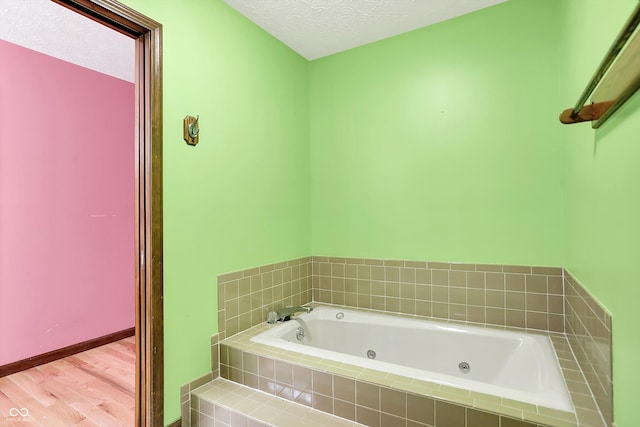 50 Charing Cross Rd, Indianapolis, IN 46217 - bathroom with a tub with jets, wood finished floors, and a textured ceiling
