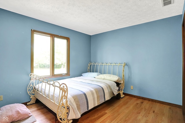 50 Charing Cross Rd, Indianapolis, IN 46217 - bedroom featuring wood finished floors, a textured ceiling, and baseboards
