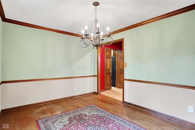 50 Charing Cross Rd, Indianapolis, IN 46217 - spare room with a chandelier, wood finished floors, ornamental molding, and baseboards