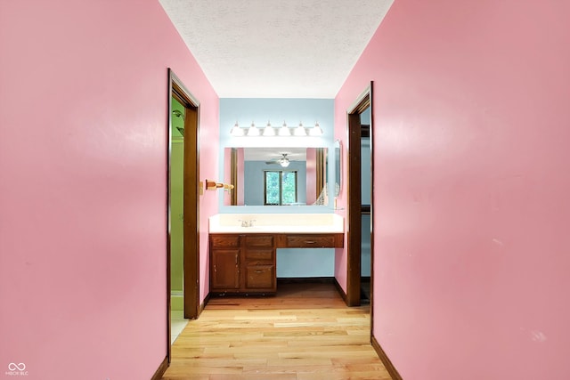50 Charing Cross Rd, Indianapolis, IN 46217 - hall featuring light wood-style flooring, an office area, a textured ceiling, a sink, and baseboards