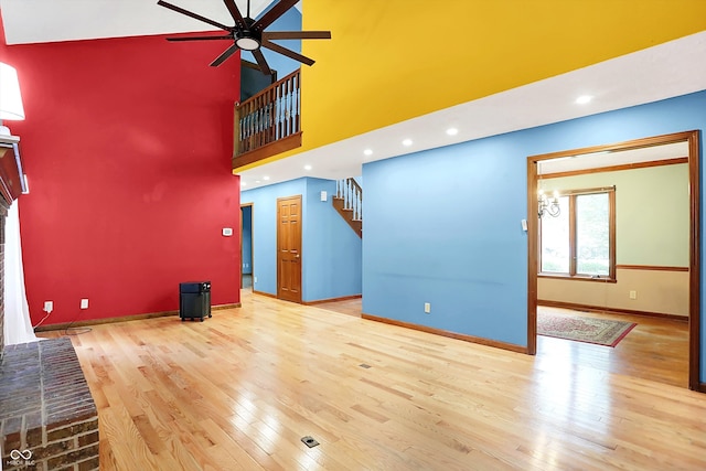 50 Charing Cross Rd, Indianapolis, IN 46217 - unfurnished living room with a ceiling fan, wood finished floors, baseboards, a towering ceiling, and stairs