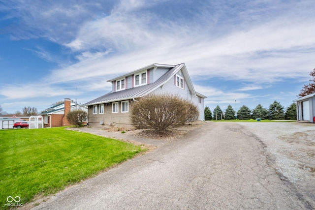 313 S Walnut St, New Castle, IN 47362 - view of side of home featuring metal roof, a lawn, a garage, driveway, and a standing seam roof