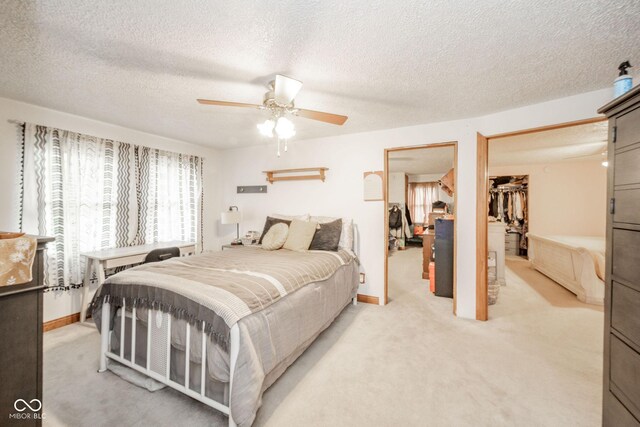 313 S Walnut St, New Castle, IN 47362 - bedroom with light carpet, baseboards, a walk in closet, a ceiling fan, and a textured ceiling