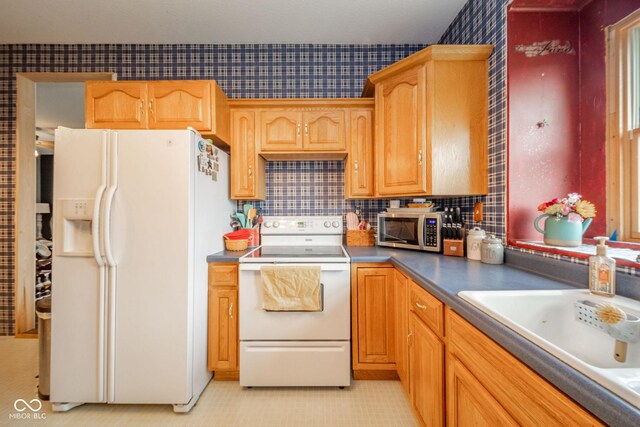 313 S Walnut St, New Castle, IN 47362 - kitchen featuring white appliances, tasteful backsplash, a sink, dark countertops, and wallpapered walls