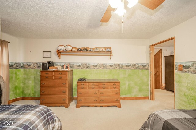 313 S Walnut St, New Castle, IN 47362 - bedroom featuring a wainscoted wall, carpet, a textured ceiling, and a ceiling fan