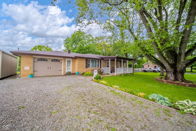 2900 Helms Rd, Anderson, IN 46016 - ranch-style home with an attached garage, gravel driveway, brick siding, a front lawn, and a sunroom