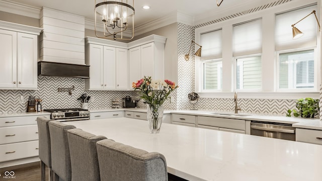 5254 N Park Ave, Indianapolis, IN 46220 - kitchen featuring appliances with stainless steel finishes, a sink, custom exhaust hood, light countertops, and a chandelier