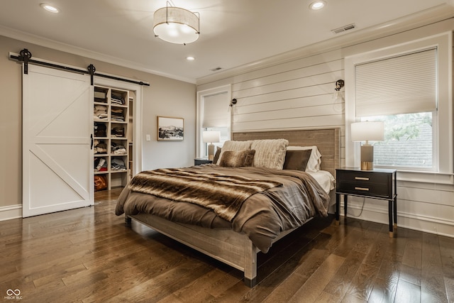 5254 N Park Ave, Indianapolis, IN 46220 - bedroom featuring crown molding, a barn door, wood finished floors, a spacious closet, and recessed lighting