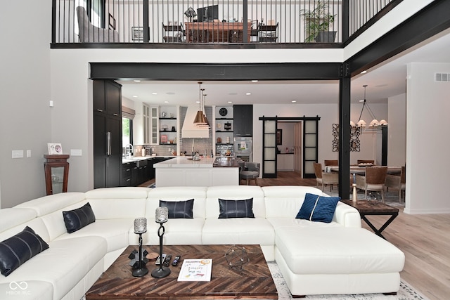 7070 Dean Rd, Indianapolis, IN 46220 - living area with a barn door, light wood finished floors, and a high ceiling