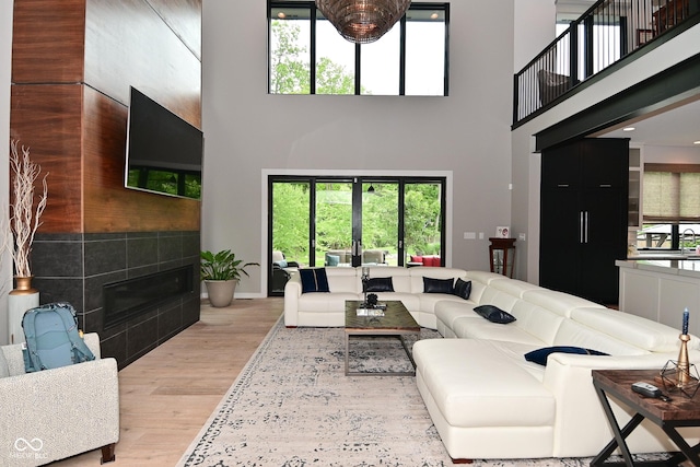 7070 Dean Rd, Indianapolis, IN 46220 - living room with a high ceiling, light wood-style flooring, plenty of natural light, a fireplace, and baseboards