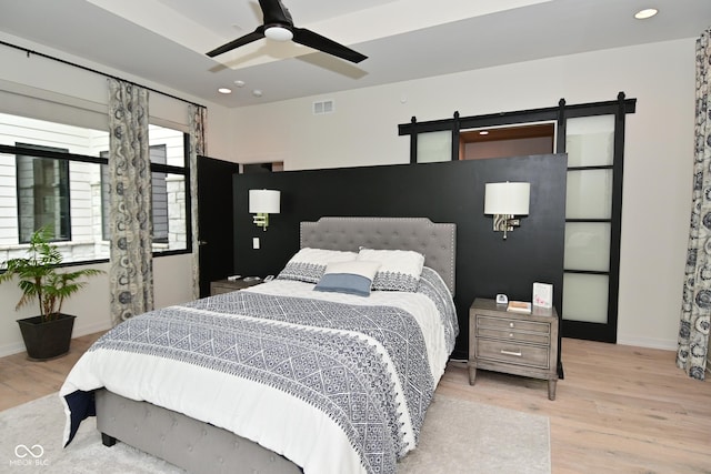 7070 Dean Rd, Indianapolis, IN 46220 - bedroom with a barn door, wood finished floors, baseboards, and recessed lighting