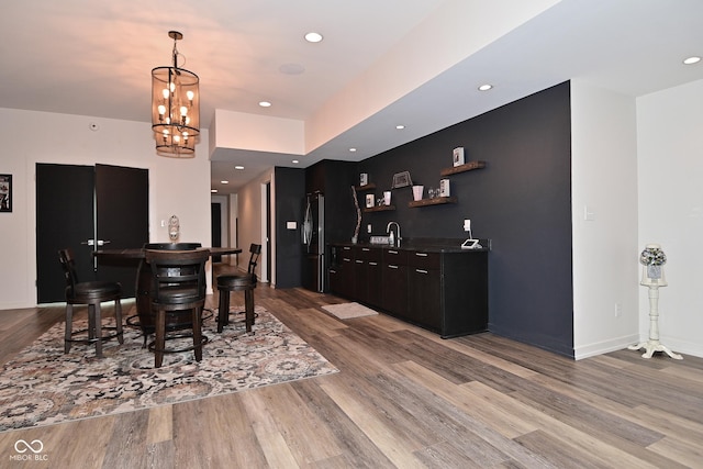 7070 Dean Rd, Indianapolis, IN 46220 - dining area with bar with sink, wood finished floors, baseboards, and recessed lighting