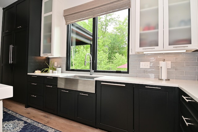 7070 Dean Rd, Indianapolis, IN 46220 - kitchen with dark cabinets, light wood finished floors, backsplash, and a sink