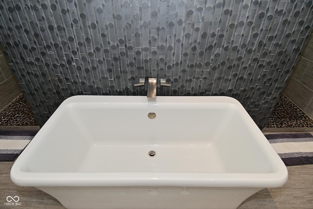7070 Dean Rd, Indianapolis, IN 46220 - bathroom featuring a freestanding tub, a tile shower, tile walls, and a sink