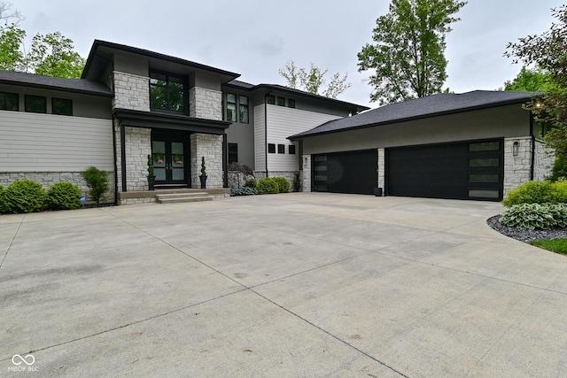 7070 Dean Rd, Indianapolis, IN 46220 - view of front of house with stone siding, french doors, an attached garage, and driveway