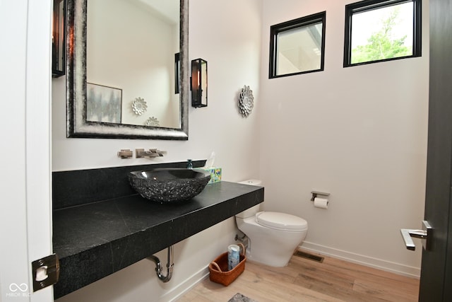 7070 Dean Rd, Indianapolis, IN 46220 - bathroom with toilet, a sink, wood finished floors, and baseboards