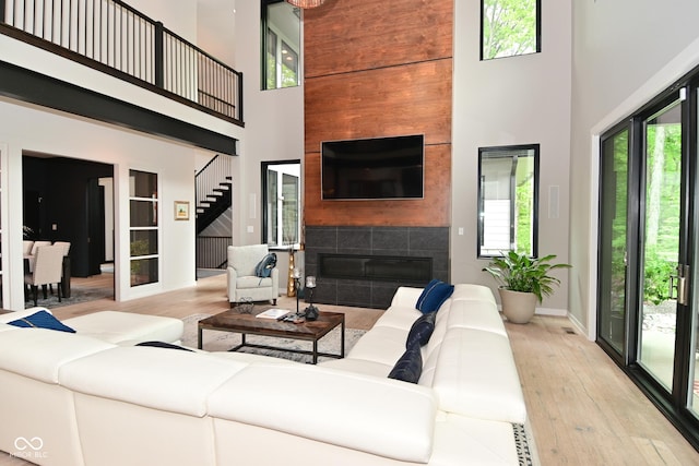 7070 Dean Rd, Indianapolis, IN 46220 - living room with a high ceiling, hardwood / wood-style floors, a tile fireplace, and baseboards