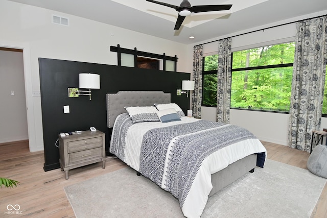 7070 Dean Rd, Indianapolis, IN 46220 - bedroom with light wood finished floors, baseboards, a barn door, a ceiling fan, and recessed lighting