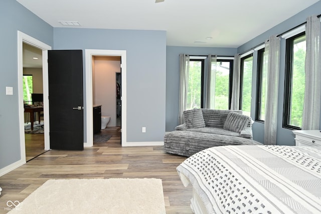 7070 Dean Rd, Indianapolis, IN 46220 - bedroom featuring multiple windows, light wood-style floors, and baseboards