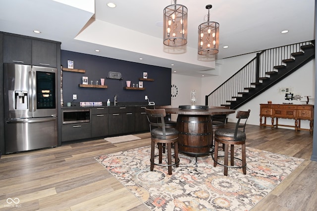 7070 Dean Rd, Indianapolis, IN 46220 - indoor wet bar with stainless steel appliances, stairs, light wood-style floors, decorative light fixtures, and recessed lighting