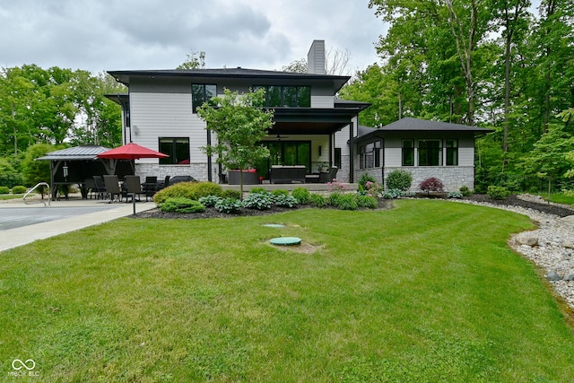 7070 Dean Rd, Indianapolis, IN 46220 - rear view of house with a chimney, a patio, stone siding, a lawn, and outdoor lounge area