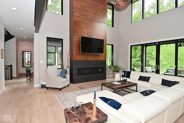7070 Dean Rd, Indianapolis, IN 46220 - living area featuring a towering ceiling, a tile fireplace, hardwood / wood-style flooring, baseboards, and recessed lighting