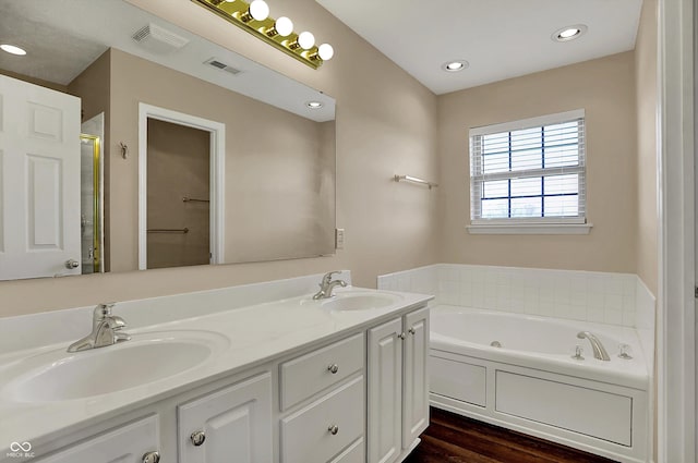 7637 Sand Run Ct, Indianapolis, IN 46259 - bathroom featuring a whirlpool tub, double vanity, wood finished floors, a stall shower, and recessed lighting