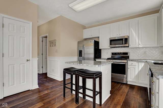 7637 Sand Run Ct, Indianapolis, IN 46259 - kitchen featuring appliances with stainless steel finishes, light stone countertops, white cabinetry, a kitchen bar, and a kitchen island