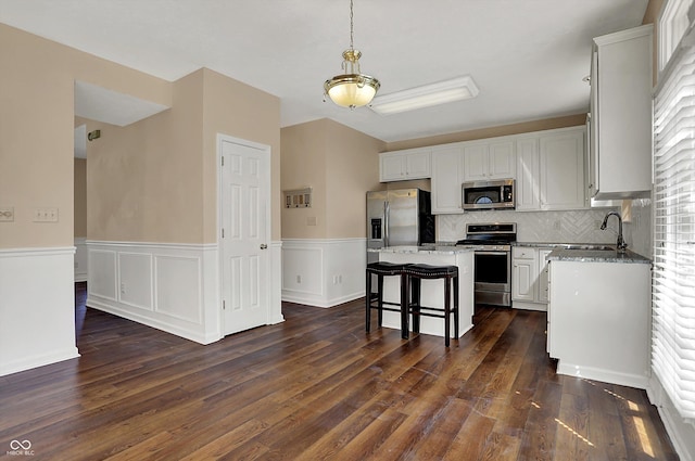 7637 Sand Run Ct, Indianapolis, IN 46259 - kitchen with appliances with stainless steel finishes, a sink, dark wood-style floors, tasteful backsplash, and a wainscoted wall