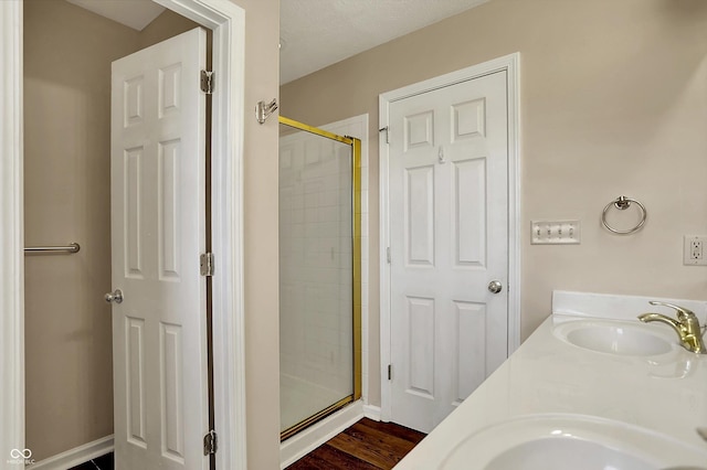 7637 Sand Run Ct, Indianapolis, IN 46259 - bathroom with a shower stall, double vanity, wood finished floors, and baseboards